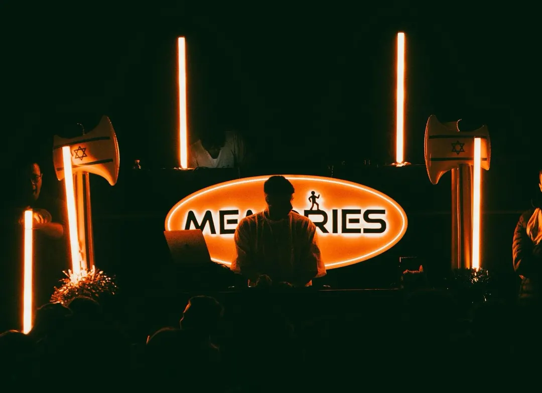 במת DJ עם לוגו Memories ואורות ניאון כתומים במסיבת נוער